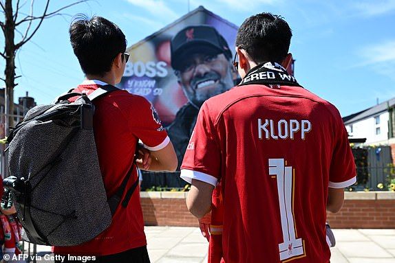 Fans stop to view a mural of Liverpool's German manager Jurgen Klopp by artist Hugh Whitaker from MurWalls near to the ground as they arrive for the English Premier League football match between Liverpool and Wolverhampton Wanderers at Anfield in Liverpool, north west England on May 19, 2024. Jurgen Klopp said Friday he has experienced the 