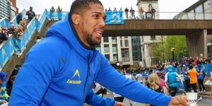Anthony Joshua provides London Marathon runner with some inspiring advice after he admitted he was struggling to finish the race... as the boxing legend handed out Lucozade and motivated entrants