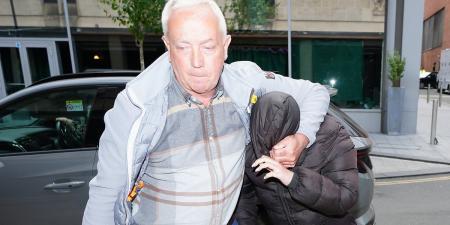 Paedophile maths teacher Rebecca Joynes hides under her coat as she arrives at court with her father to be sentenced for having sex with two teenage schoolboys