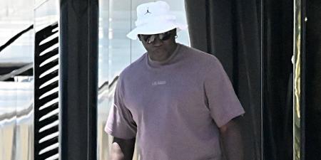 Michael Jordan smokes a cigar as he heads out for dinner in Barcelona - as NBA icon soaks up the sun with wife Yvette Prieto on his $15m yacht