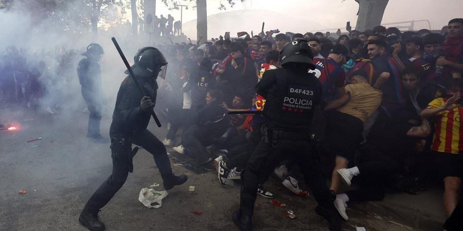 Barcelona fans mistakenly throw objects at their OWN team bus as they clash with police in violent scenes outside the stadium ahead of Champions League showdown with PSG