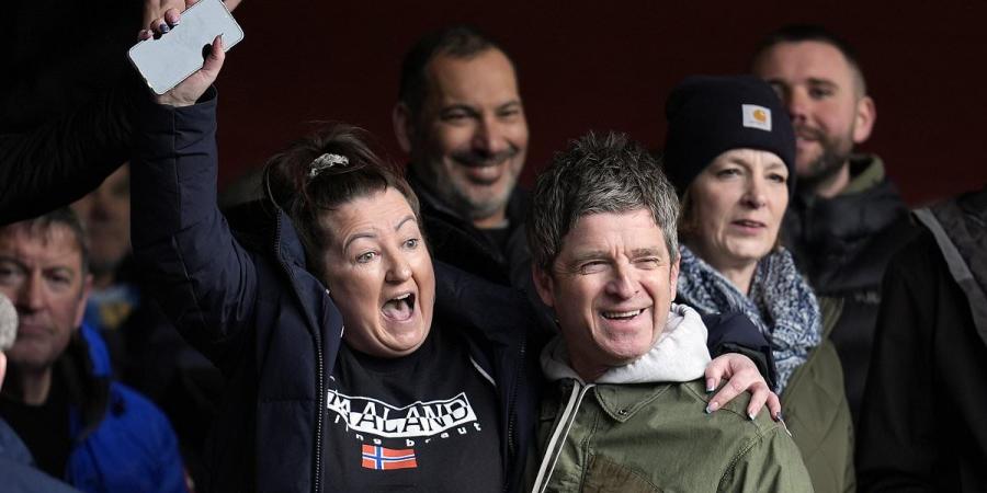 Man City superfan Noel Gallagher celebrates with supporters in the away end as the champions move one point behind leaders Arsenal with 2-0 win at Nottingham Forest