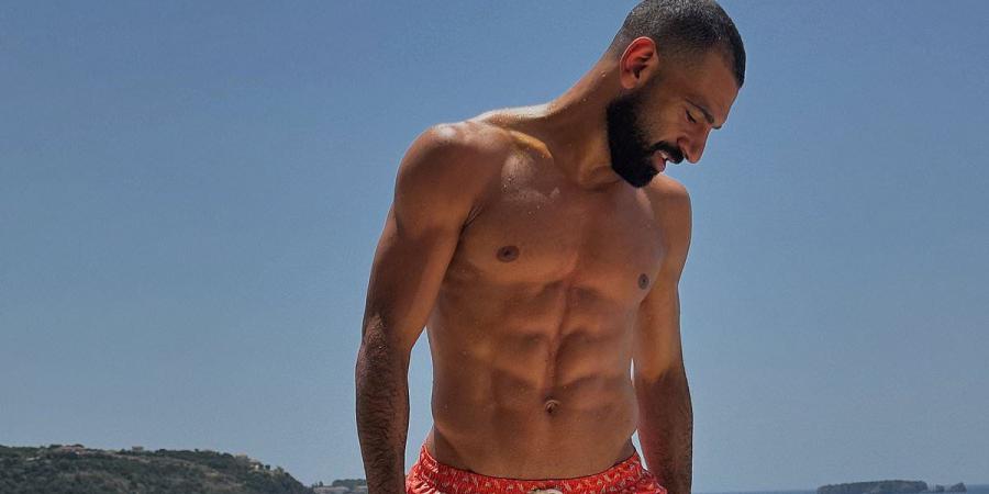 Mohamed Salah unveils his shock hairstyle transformation and shredded abs on holiday after shaving off his trademark afro... as he rests up by the pool ahead Liverpool's new season